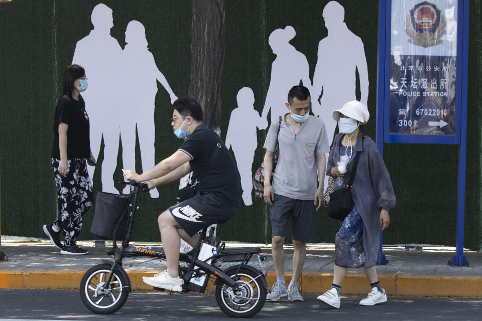 Residents wear masks to curb the spread of the new coronavirus on a street of Beijing on Thursday, June 18, 2020. China's capital Beijing reported a decline in newly confirmed cases of coronavirus Thursday as the city continued to press stricter measures to contain a new outbreak. (AP Photo/Ng Han Guan)