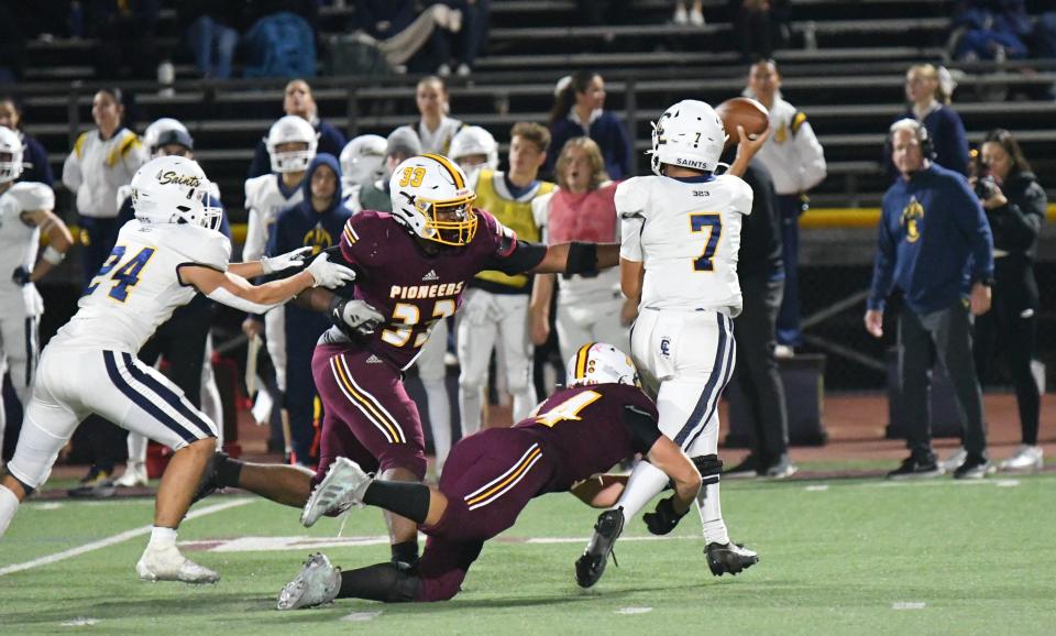 Simi Valley's Thomas Humphrey (bottom) and Izak Simpson (33) pressure Crean Lutheran quarterback Jeremiah Finaly during the Pioneers' 27-7 win in a CIF-SS Division 6 quarterfinal game on Nov. 10.
