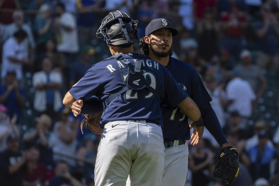 Seattle Mariners catcher Cal Raleigh, left, and relief pitcher Andres Munoz celebrate after a baseball game against the Cleveland Guardians, Thursday, Aug. 25, 2022, in Seattle. (AP Photo/Stephen Brashear)