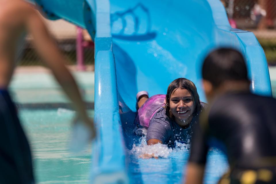 Kids go down the waterslide at the Pavo Real Enhanced Spray Park at 9301 Alameda Ave. on Tuesday to cool off for the summer.