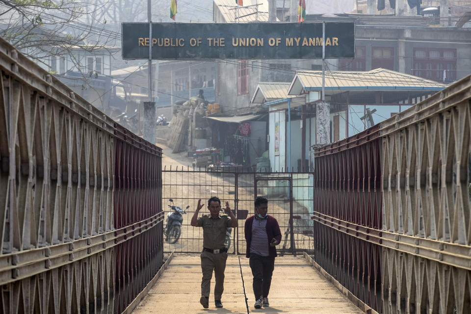 An Indian police officer and an Indian man walk on a bridge across Tiau river along the India-Myanmar border in Champhai village, in Mizoram, India, Saturday, March 20, 2021. Several Myanmar police officers who fled to India after defying army orders to shoot opponents of last month’s coup are urging Prime Minister Narendra Modi’s government to not repatriate them and provide them political asylum on humanitarian grounds. (AP Photo/Anupam Nath)