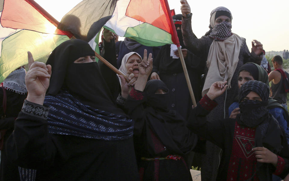 Female protesters wave flags while chanting slogans during a protest at the entrance of Erez border crossing between Gaza and Israel, in the northern Gaza Strip, Tuesday, Sept. 4, 2018. The Health Ministry in Gaza says several Palestinians were wounded by Israeli fire as they protested near the territory's main personnel crossing with Israel. (AP Photo/Adel Hana)