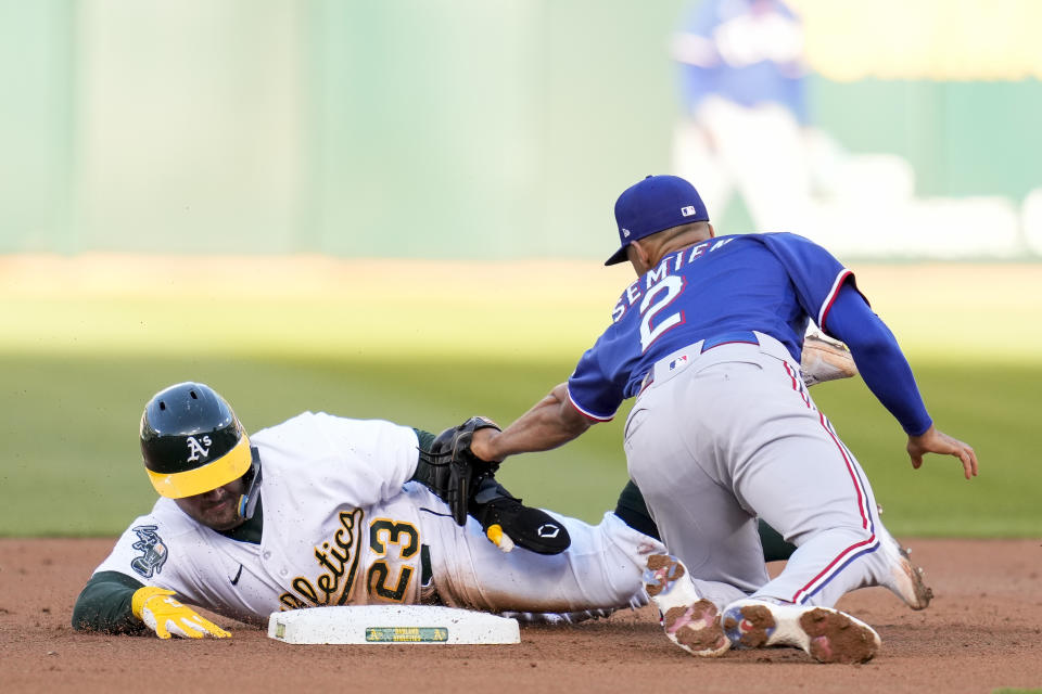 Texas Rangers second baseman Marcus Semien, right, tags out Oakland Athletics' Shea Langeliers on a steal attempt during the second inning of a baseball game in Oakland, Calif., Thursday, May 11, 2023. (AP Photo/Godofredo A. Vásquez)