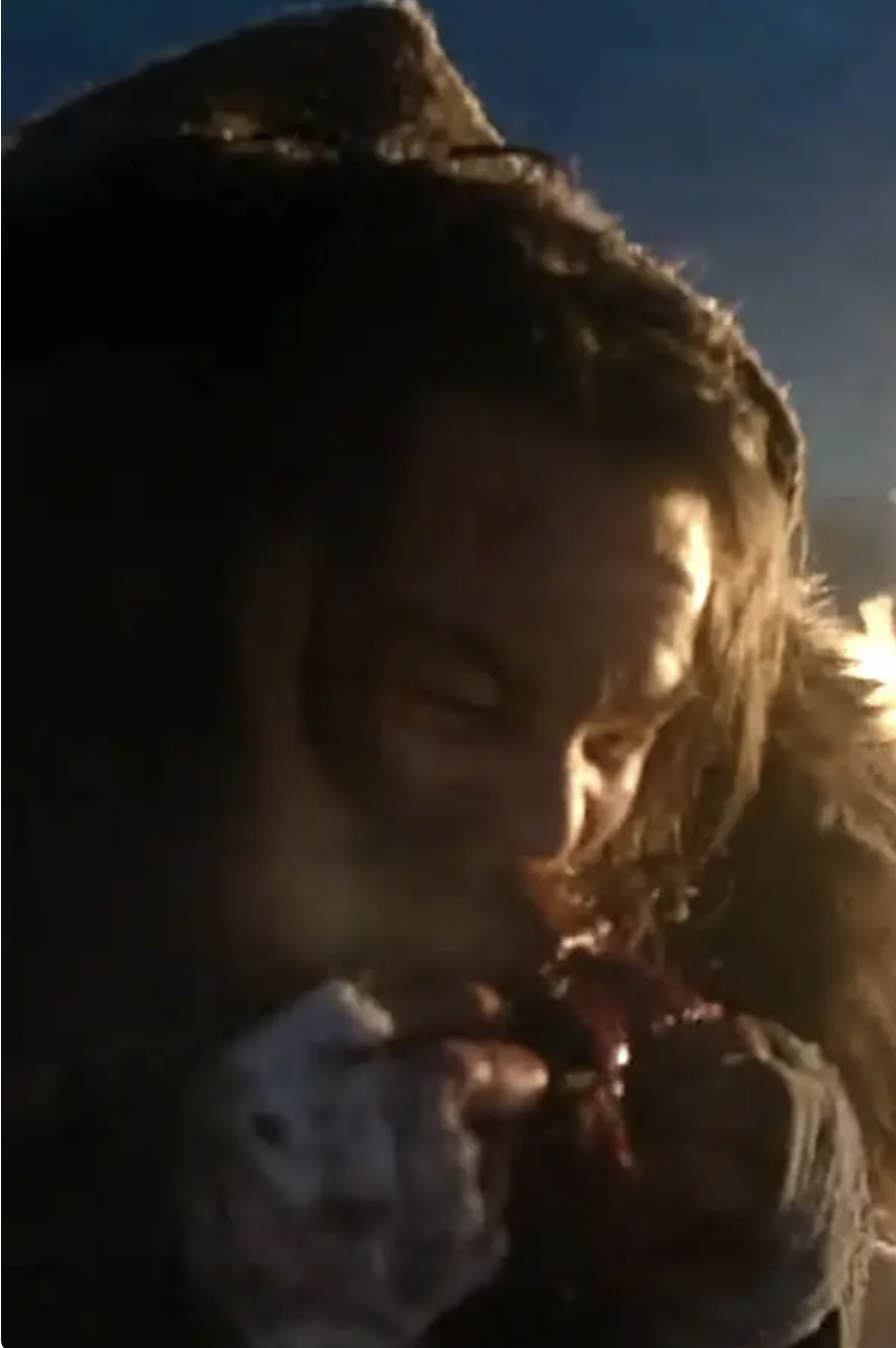 Leonardo DiCaprio as Hugh Glass in a scene from "The Revenant," focusing closely on his face as he eats raw liver