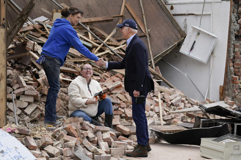 President Joe Biden meets with people as he surveys storm damage from tornadoes and extreme weather in Mayfield, Ky., Wednesday, Dec. 15, 2021. (AP Photo/Andrew Harnik)