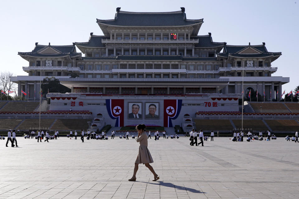 A woman walks past the preparations ongoing on Kim Il Sung Square, ahead of the 70th anniversary of North Korea's founding day in Pyongyang, North Korea, Friday, Sept. 7, 2018. North Korea will be staging a major military parade, huge rallies and reviving its iconic mass games on Sunday to mark its 70th anniversary as a nation. (AP Photo/Kin Cheung)