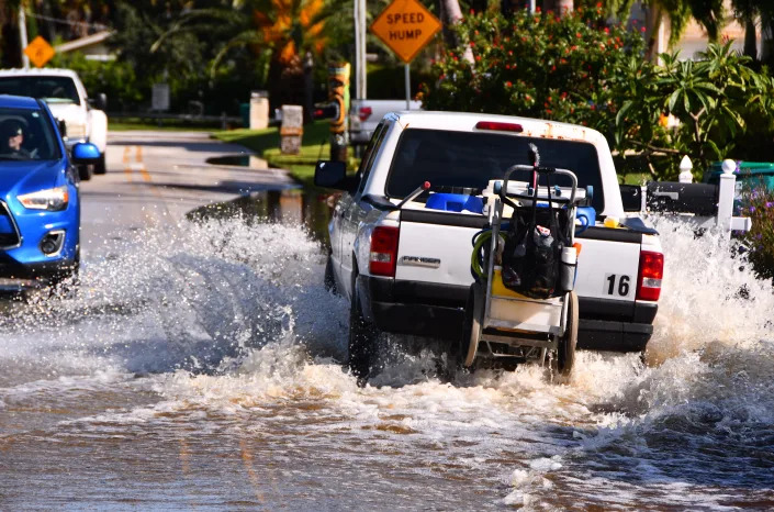 A truck makes its way down Milford Point Drive on Merritt Island after heavy rains pounded Brevard County in September 2022, flooding streets and yards. Rising sea levels are expected to make flooding a more common problem in Florida even in the absence of hurricanes.