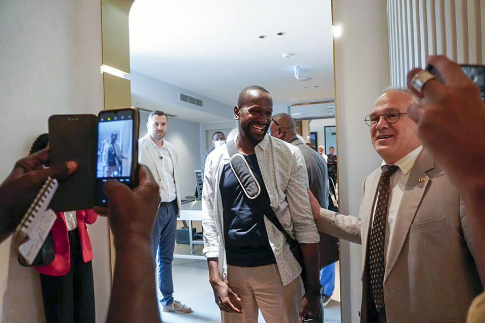 French journalist Olivier Dubois, center, is greeted by Sylvain Itte, French Ambassador to Niger at the VIP lounge at the airport in Niamey, Niger, Monday March 20, 2023. Dubois, who was abducted almost two years ago, was released alongside American aid worker Jeffery Woodke who was held by Islamic extremists in West Africa for more than six years. The two men were the highest-profile foreigners known to be held in the region, and their release was the largest since a French woman and two Italian men were freed together in Mali back in Oct. 2020. (AP Photo/Judith Besnard)