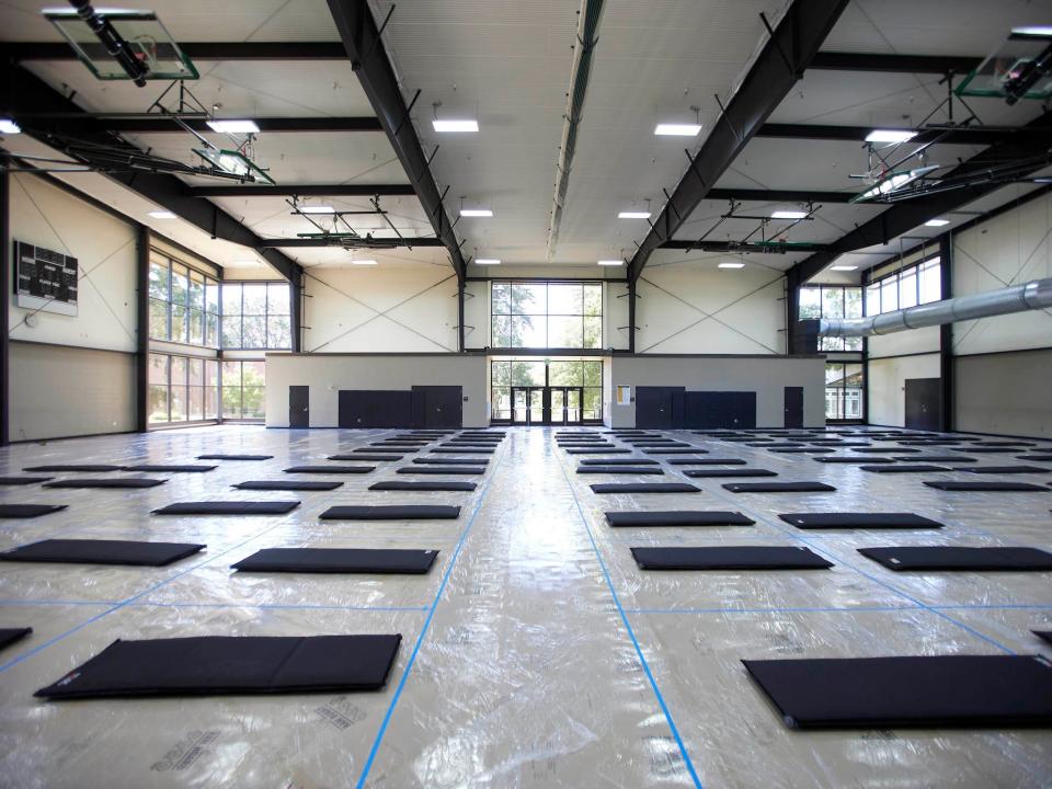 mats lined up on the floor of a large gymnasium-style room