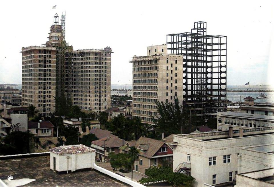 This colorized photograph from 1925 shows the steel frame of the Watson Hotel, later known as the Miami Colonial Hotel, while the building was under construction in downtown Miami. The Exchange office building, from 1923, sits directly behind it. At left is the Everglades Hotel.