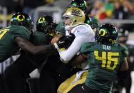 EUGENE, OR - DECEMBER 02 : Quarterback Kevin Prince #4 of the UCLA Bruins is tackled by a host of Oregon Ducks including linebacker Michael Clay #46 of the Oregon Ducks in the first quarter of the Pac-12 Championship game against the UCLA Bruins at Autzen Stadium on December 2, 2011 in Eugene, Oregon. (Photo by Steve Dykes/Getty Images)