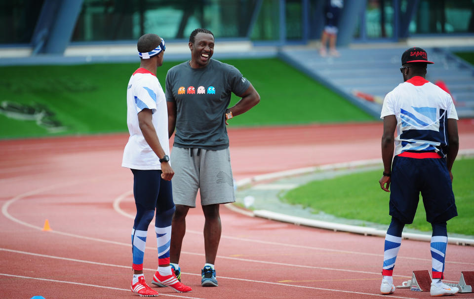 MONTE GORDO, PORTUGAL - JULY 25:  Coach Linford Christie (r) shares a joke with runner Conrad Williams during the Team GB Track and Field preperation camp at Monte Gordo Stadium on July 25, 2012 in Monte Gordo, Portugal.  (Photo by Stu Forster/Getty Images)