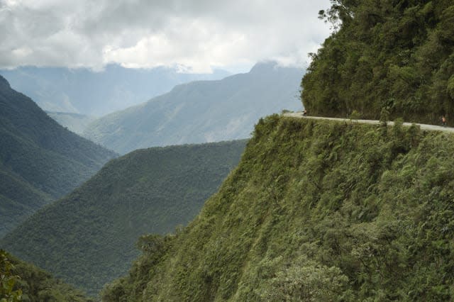 Cyclists riding on the Death Road - the most dangerous road in the world, North Yungas, Bolivia.