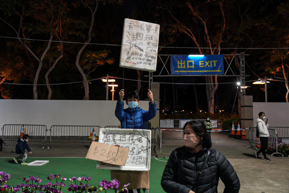 不少花農要提早促銷減價，出動小朋友舉牌吸引途人注意。