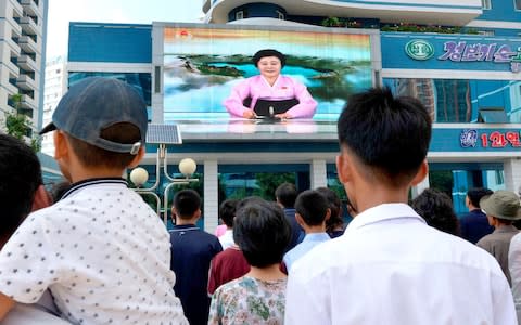 North Koreans watch a news report showing North Korea's nuclear test on electronic screen in Pyongyang  - Credit: KYODO