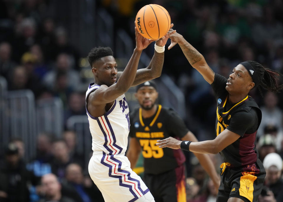 TCU guard Damion Baugh, left, passes the ball as Arizona State guard DJ Horne defends in the first half of a first-round college basketball game in the men's NCAA Tournament, Friday, March 17, 2023, in Denver. (AP Photo/David Zalubowski)