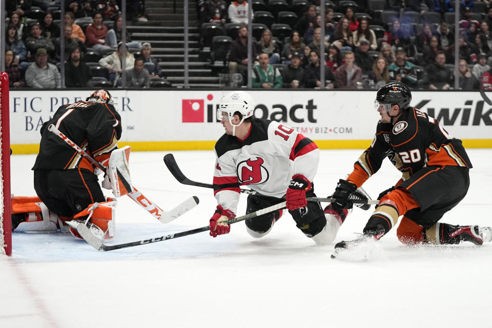 New Jersey Devils right wing Alexander Holtz, center, tries to get a shot past Anaheim Ducks goaltender Lukas Dostal, left, as right wing Brett Leason defends during the second period of an NHL hockey game Friday, March 1, 2024, in Anaheim, Calif. (AP Photo/Mark J. Terrill)