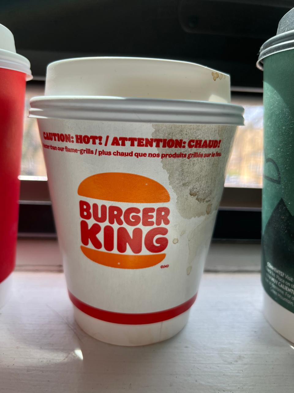 cup of burger king coffee sitting on a window ledge