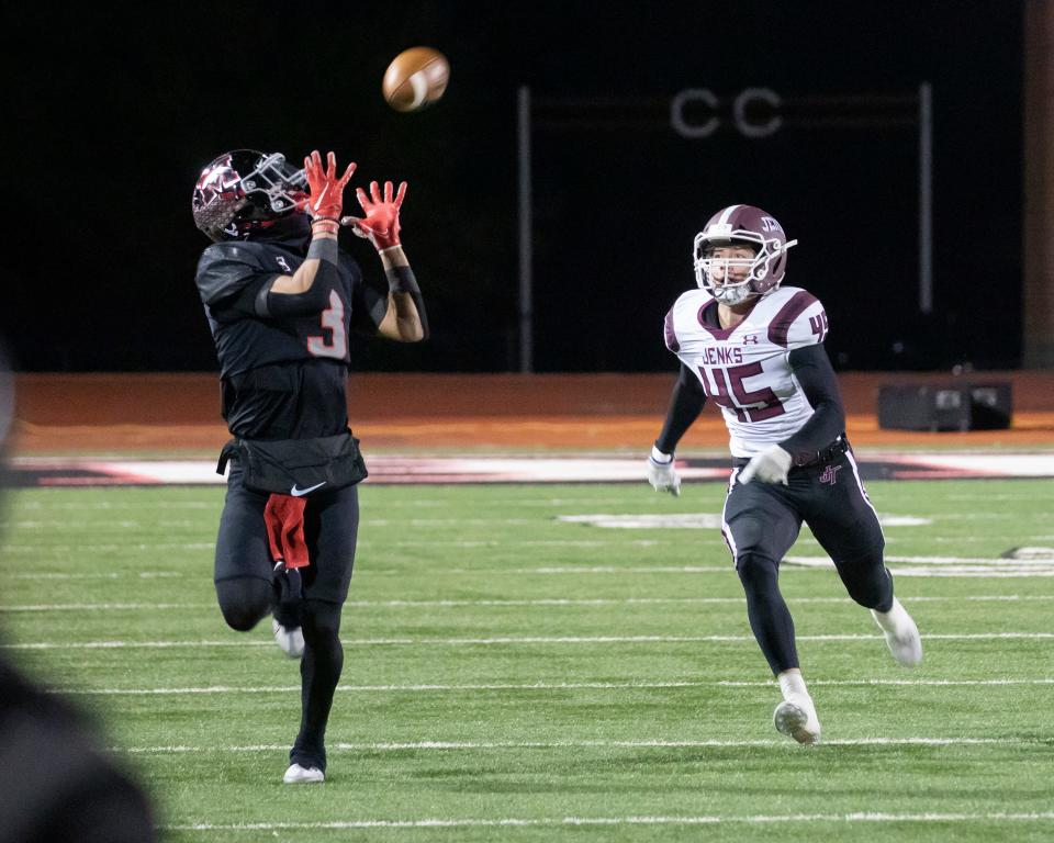 MustangÕs Jacobe Johnson (3) catches a ball, followed by JenksÕ Sam Stone (45) during a high school football game between Mustang and Jenks, Friday, Nov. 18, 2022, in Mustang, Okla. 