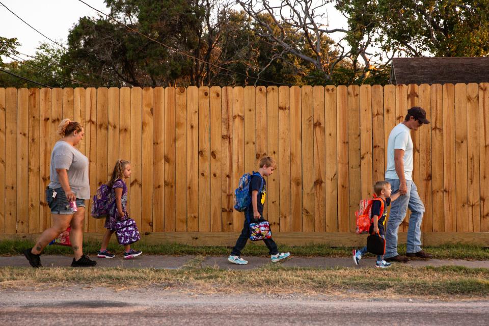 Nathan and Erica Kozski walk children, from left, Freya, Matthew and Wyett, to Cullen Place Elementary on the first day of school, Wednesday, Aug. 9, 2023, in Corpus Christi, Texas.