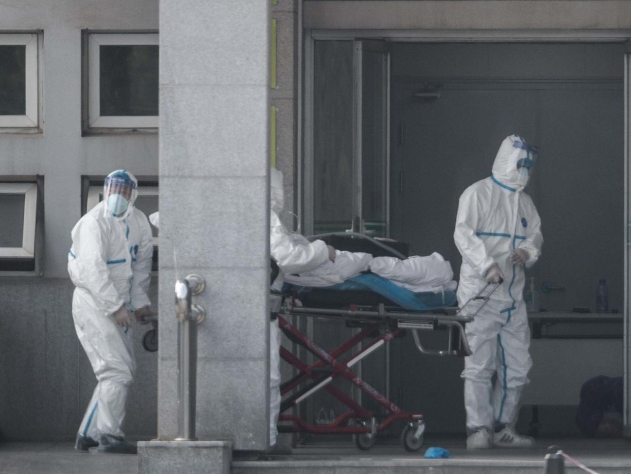 Medical staff carry a patient into the Jinyintan hospital, where patients infected with a new strain of Coronavirus identified as the cause of the Wuhan pneumonia outbreak are being treated: EPA