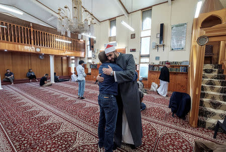 Australian journalist Dean Yates hugs Imam Alaa El Zokmat at the Elsedeaq Heidelberg Mosque, located in the Melbourne suburb of Heidelberg in Australia, March 2, 2018. REUTERS/Luis Enrique Ascui