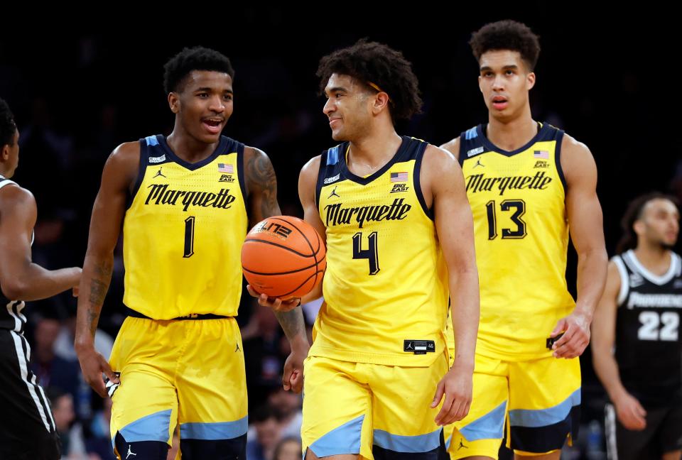 Marquette's Kam Jones, left, Stevie Mitchell, center, and Oso Ighodaro react in their victory over the Providence in the semifinals of the Big East tournament at Madison Square Garden on Friday night.