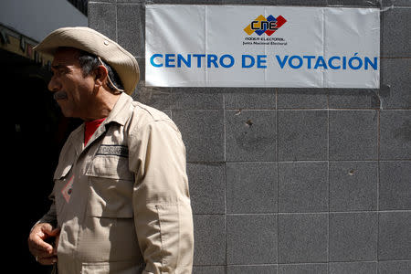 A militia member stands guard at a polling station during the municipal legislators election in Caracas, Venezuela December 9, 2018. REUTERS/Marco Bello
