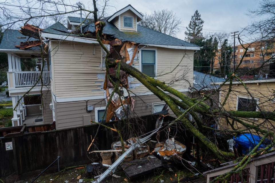 A fallen tree pierced through a home near 13th and D streets in Sacramento’s Mansion Flats neighborhood on Wednesday, Jan. 27, 2021, after a storm with severe wind gusts came through the area overnight.