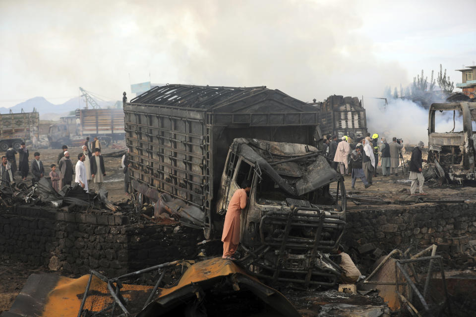 A driver views the damage of his truck caught in a fire in Kabul, Afghanistan, Sunday, May 2, 2021. A fire roared through several fuel tankers on the northern edge of the Afghan capital late Saturday, injuring at least 10 people and plunging much of the city into darkness, officials said. (AP Photo/Rahmat Gul)