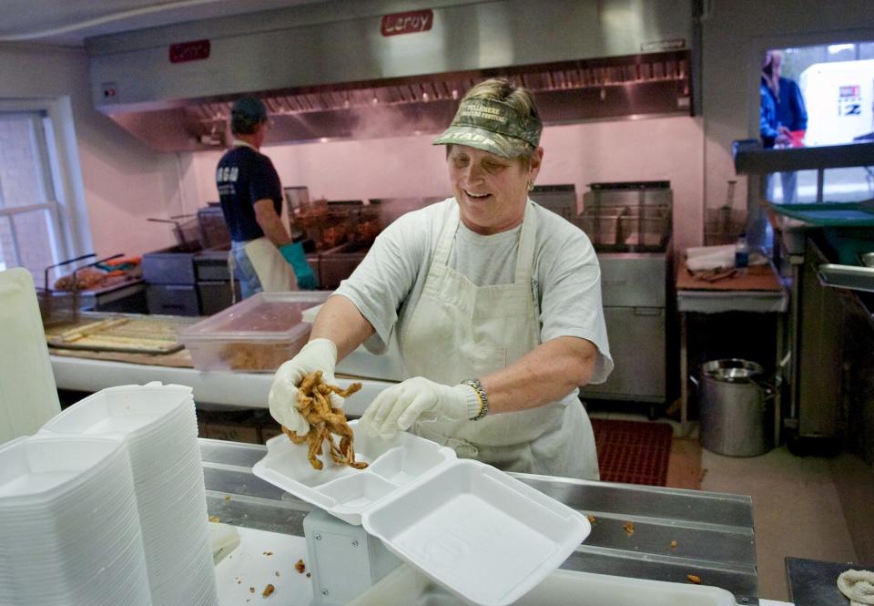 Fran Adams, founder of the Fellsmere Frog Leg Festival, one of the community's unique events, loads a plate with frog legs while working the event on Friday evening Jan. 21, 2011. Four-thousand pounds of frog legs and 2,500 pounds of gator tail were brought in for the event. "I was shooting for 6,000 dinners this year," said Ali Martin, kitchen manager for the festival.