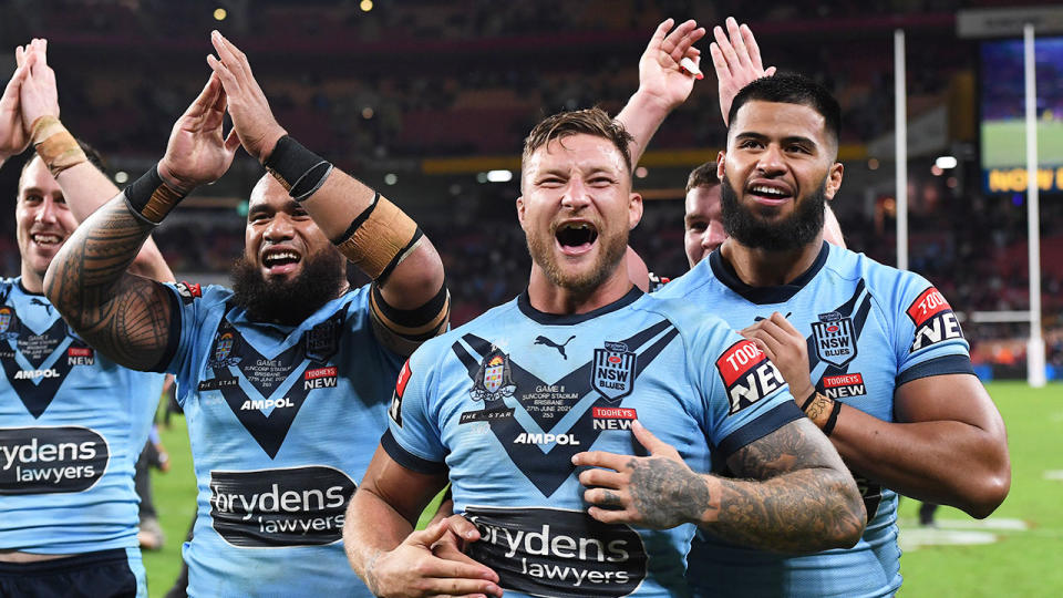 Pictured here, NSW Blues players celebrate after clinching the Origin series in Game II.