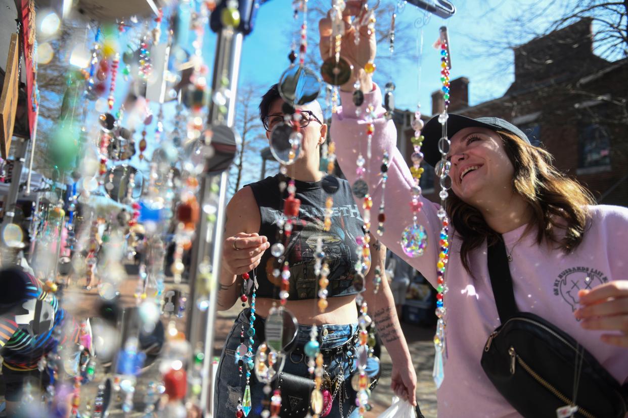 FILE - Brittany Bedolla (left) and Mary Gribi (right) look at suncatchers outside Nina's Shop at the opening day of the Augusta Market at the Augusta Riverwalk on Saturday, March 16, 2024. The farmer's market will open on Saturdays until November.