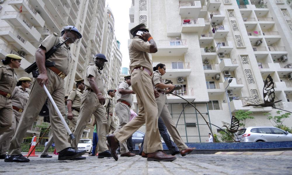 Policemen stand guard outside a housing society, Mahagun Moderne in Noida, India. 