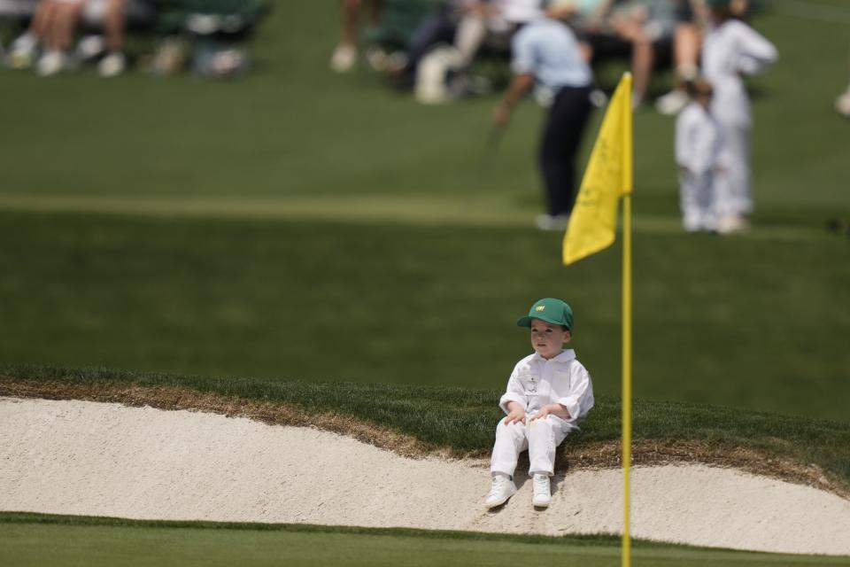 Charlie, son of, Nick Taylor, of Canada, watches his dad play on the sixth hole during the par-3 contest at the Masters golf tournament at Augusta National Golf Club Wednesday, April 10, 2024, in Augusta, GA. (AP Photo/Charlie Riedel)