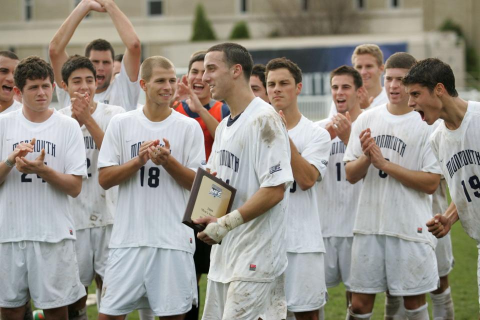 Hawk's RJ Allen is cheered on by his teammates as he walks up to accept the trophy for MVP. Monmouth University Hawk's compete against
Quinnipiac's Bobcats in the Northeast Conference Men's Soccer Championship at Monmouth University, Sunday, November 15, 2009. STAFF PHOTO/MARY FRANK - W. LONG BRANCH - SPORTS - #9859.