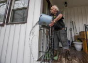 <p>Robert Forler tosses a bucket out water off his front porch as he tries to clear standing water from his home on Emerson Avenue Wednesday, Feb. 21, 2018, in South Bend, Ind. (Photo: Robert Franklin/South Bend Tribune via AP) </p>