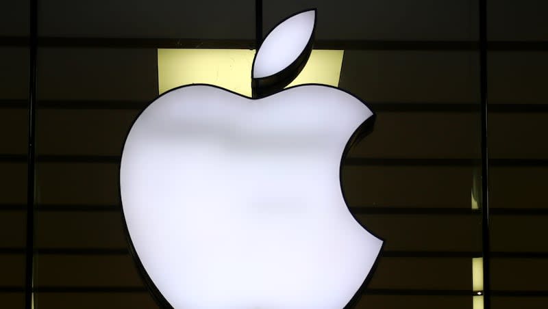 The Apple logo is illuminated at a store in the city center of Munich, Germany, Dec. 16, 2020.