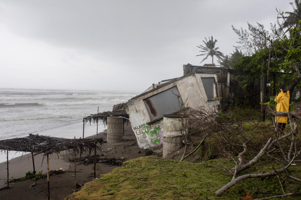 A journalist takes pictures of a damaged house that was damaged by winds brought on by Hurricane Grace, in Tecolutla, Veracruz State, Mexico, Saturday, Aug. 21, 2021. Grace hit Mexico’s Gulf shore as a major Category 3 storm before weakening on Saturday, drenching coastal and inland areas in its second landfall in the country in two days. (AP Photo/Felix Marquez)