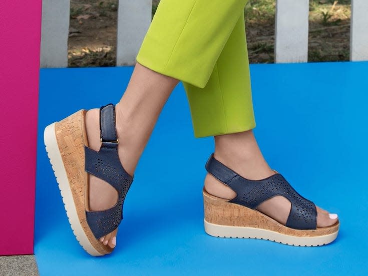 close up of someone leaning against a wall made of lime green pants and cork wedges