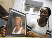 Veronica Parker holds a photo of her son, Korey B. Parker, Sr., 27, at her workplace in Chicago, Friday, Nov. 9, 2018. He was fatally shot around the corner from her house on July 4, 2012. The killing remains unsolved. Parker is a member of Purpose Over Pain, a support group for parents who've lost children to gun violence. (AP Photo/Nam Y. Huh)