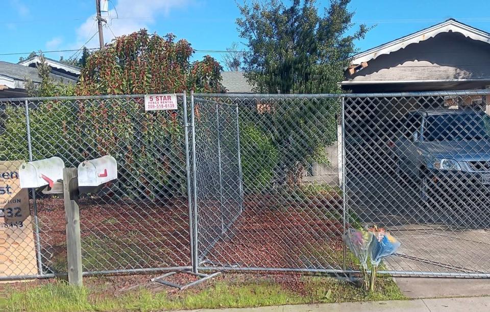 Flowers rest on a fence at a Modesto duplex where a fire Tuesday, Feb. 20, 2024, claimed the life of a 76-year-old woman. The Celeste Drive duplex is shown Wednesday.