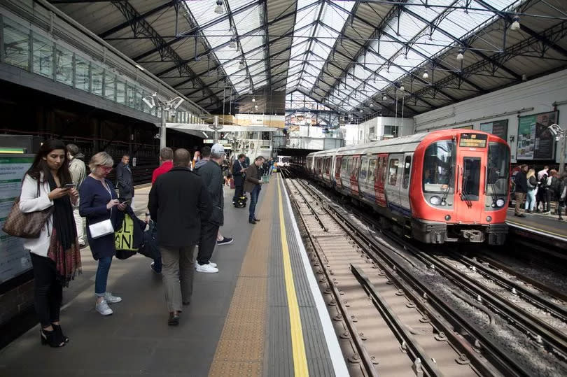 Tube train arriving at Earls Court underground station