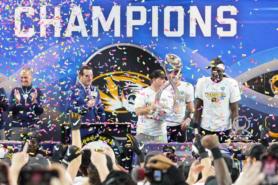 December 29, 2023;  Arlington, Texas, USA;  Missouri Tigers coach Eliah Drinkwitz holds up the Field Scovell Trophy following their 14-3 victory over the Ohio State Buckeyes in the Goodyear Cotton Bowl Classic at AT&T Stadium.