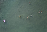 People swim during a heatwave, at a beach of Kavouri suburb, southwest of Athens, Greece, Monday, Aug. 2, 2021. The heat wave is expected to peak Monday, with temperatures inland ranging from 42 to 46 degrees Celsius (107.6 to 114.8 Fahrenheit). Temperatures will remain at 40 Celsius (104 Fahrenheit) or above in much of Greece until at least Friday, meteorologists say. (AP Photo/Michael Varaklas)