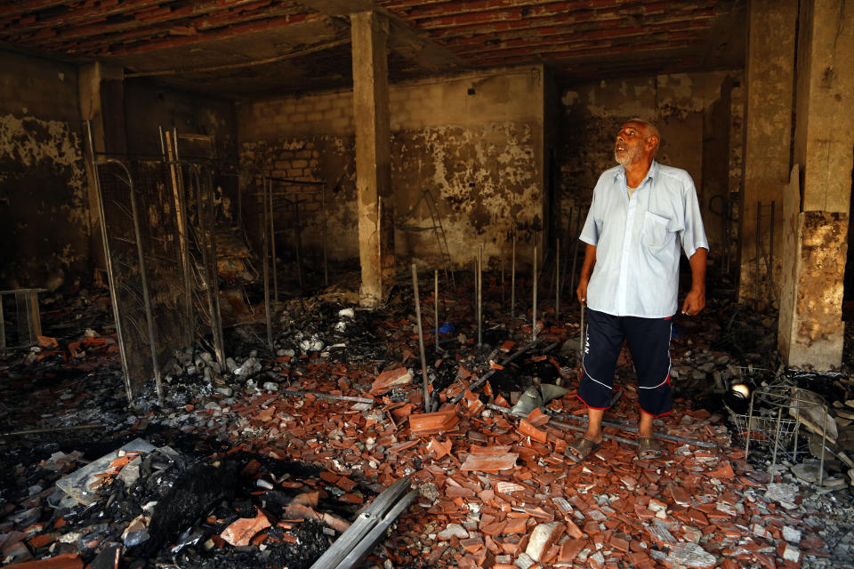 A man surveys the damage from clashes in the Libyan capital of Tripoli, Sunday, August 28 2022. Deadly clashes broke out Saturday in Libya's capital between militias backed by its two rival administrations, portending a return to violence amid a long political stalemate. (AP Photo/Yousef Murad)