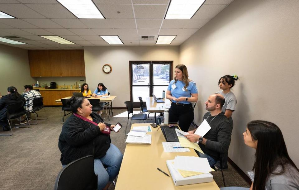 Downey business teacher Tera Coleman, her students, and United Way CEO Keristofer Seryani, seated, help Crystal Gonzalez, left, file her tax return as part of the Volunteer Income Tax Assistance program (VITA) at the United Way office in Modesto, Calif., Saturday, March 16, 2024. Andy Alfaro/aalfaro@modbee.com