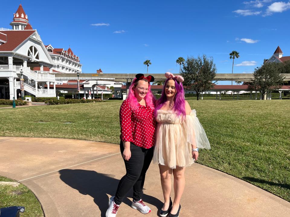 casey and jenna posing for a photo outside of the grand floridian resort at disney world