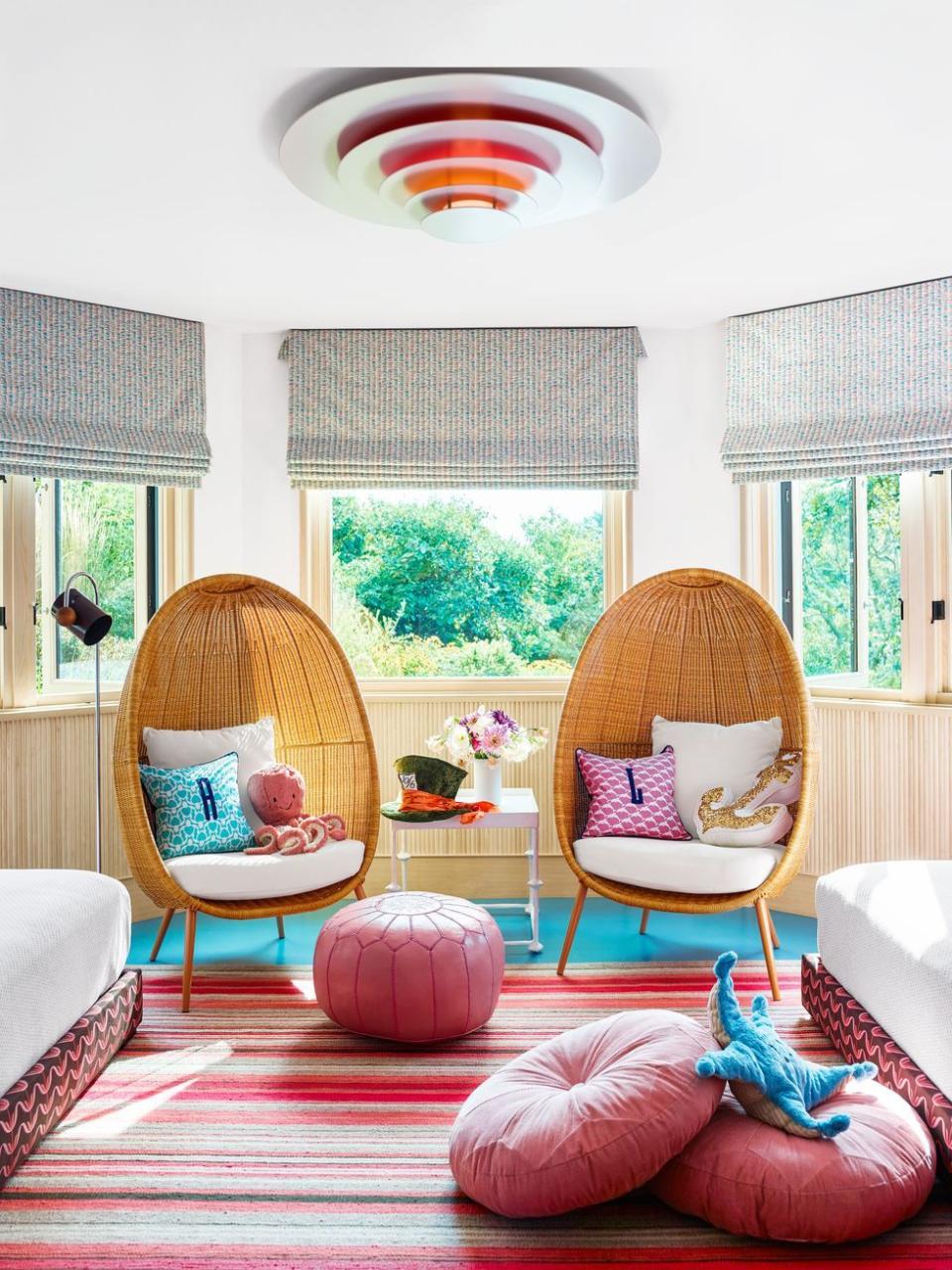 a living room with a pink rug and chairs