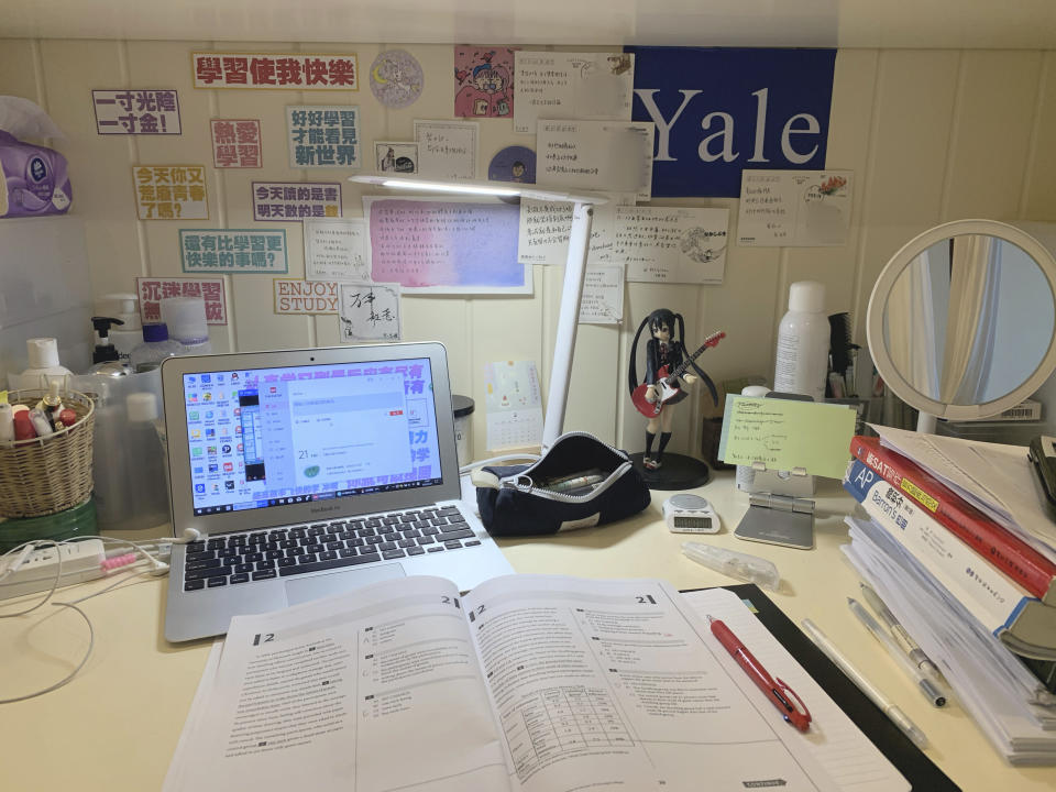 This Feb. 26, 2020 photo released by Tan Weiwei, shows a view of the 17-year-old's desk in Changsha, in southern China's Hunan province. She spent her winter break studying for the SAT, an exam that foreign students must take to enroll in American universities, facing a wall plastered with motivational slogans. When the March exam she was registered for in Malaysia was canceled due to concerns over the coronavirus, she said she felt lost and anxious about what it could mean for her dream of studying in the U.S. (Tan Weiwei via AP)